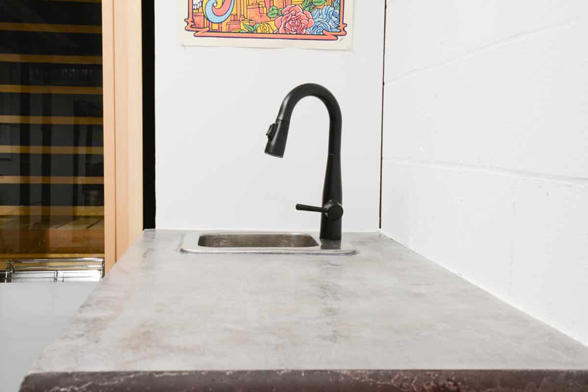 concrete counters with small wet bar sink.