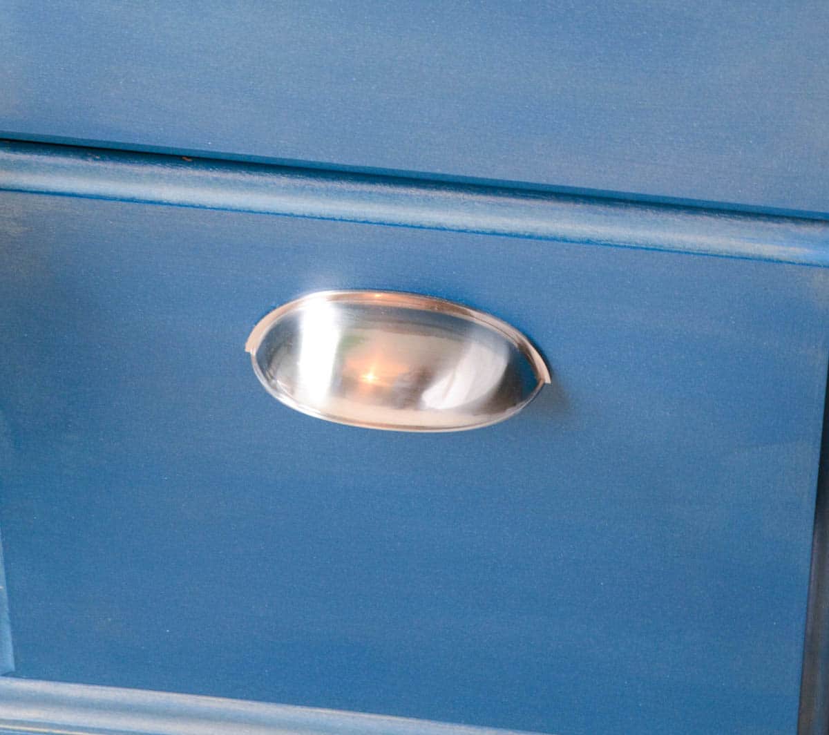 large silver pulls on blue desk drawer.