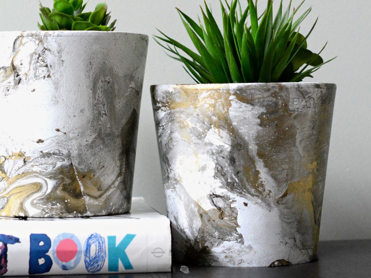 faux marble flower pots with green plants.