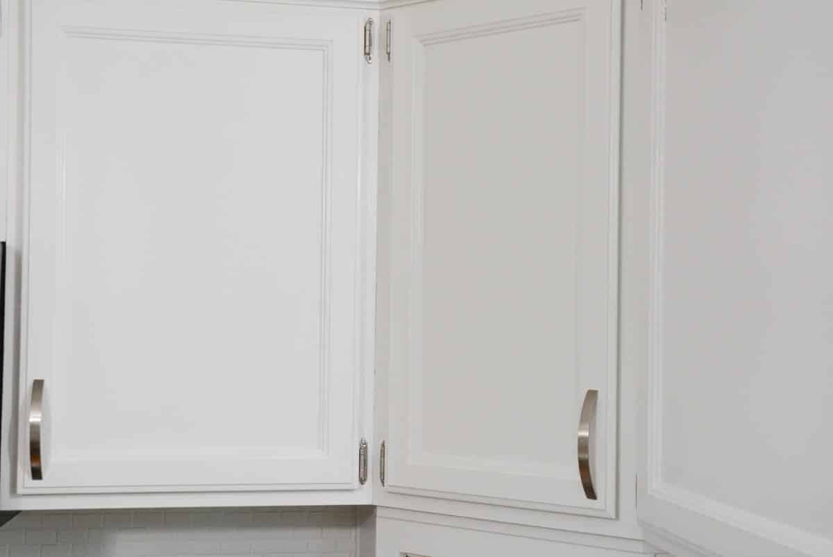 upper oak doors kitchen cabinet doors painted white with silver hinges and hardware.