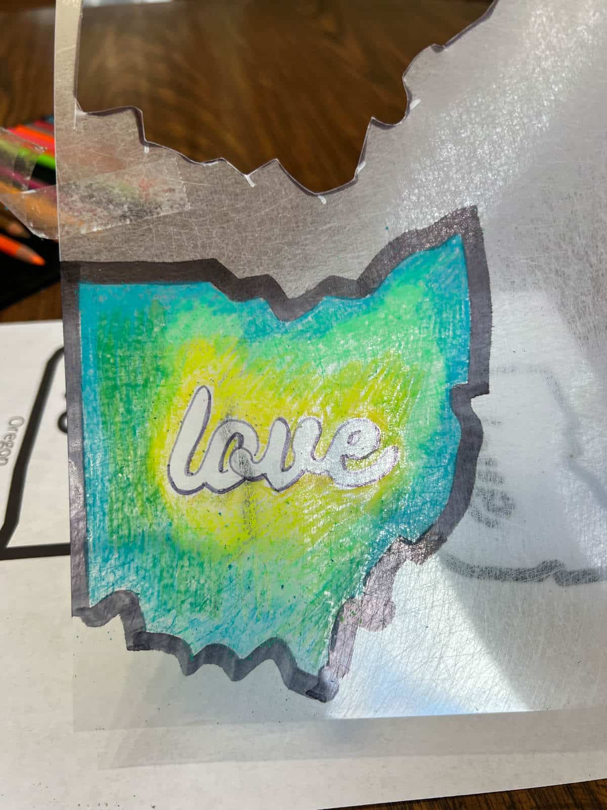 State of Ohio drawing on shrink film with green and yellow colored pencil design.
